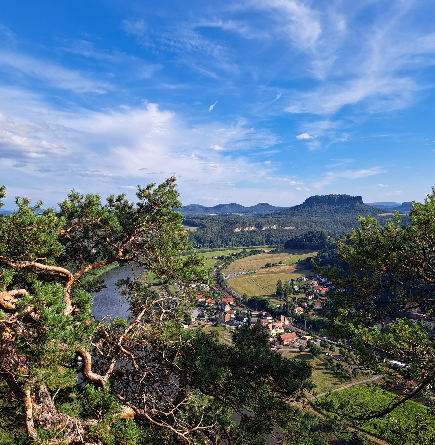 Blick vom Basteifelsen in das Elbtal flussaufwärts, blauer Himmel mit Schleierwolken, im Hintergrund Liliensteinfelsen